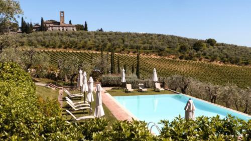 una piscina con tumbonas y sombrillas en Fattoria Abbazia Monte Oliveto, en San Gimignano