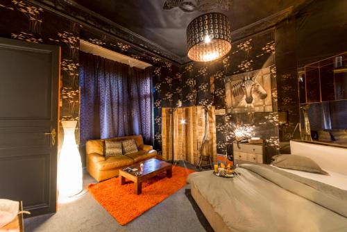 a bedroom with a bed and a couch and a chair at Le Vénitien in Liège