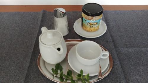 einen Teller mit zwei Tassen und eine Teekanne auf dem Tisch in der Unterkunft Ferienherbergen S & J Zeisz in Podersdorf am See