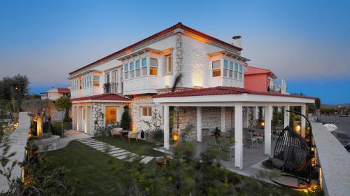 a large house with a porch on a street at Eritrina Alacati in Alacati