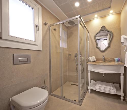 a bathroom with a shower and a toilet and a sink at Eritrina Alacati in Alacati