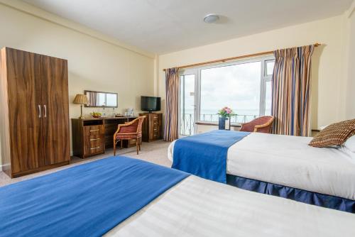 a hotel room with two beds and a television at Ocean View in Shanklin