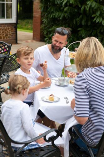 a man and two children sitting at a table eating food at Heacham Manor Hotel in Hunstanton