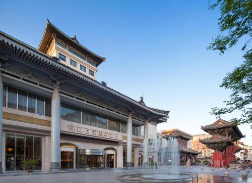 a building with a fountain in front of it at Jin Jiang West Capital International Hotel the Bell and Drum Tower Muslim quarter & Metro Line 6 & indoor swimming pool & self-service free laundry room in Xi'an
