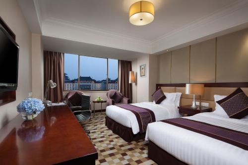 a hotel room with two beds and a desk at Jin Jiang West Capital International Hotel in Xi'an