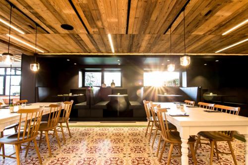 a dining room with tables and chairs and a couch at Wirthshof Hotel & Chalets in Markdorf