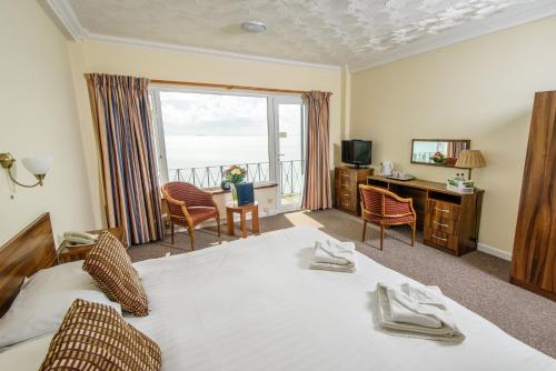 a bedroom with a bed and a view of the ocean at Ocean View Hotel in Shanklin