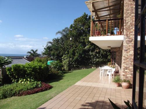 a garden with a patio with a table and chairs at Fig Tree Manor Self Catering in Blythedale