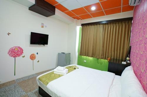 a bedroom with a white bed and a pink wall at 台東市安慶67套房館歡迎短租長租 in Taitung City