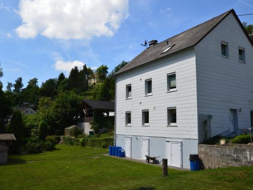 eine weiße Scheune mit grauem Dach in der Unterkunft Apartment close to hiking and cycling trails in Lambertsberg