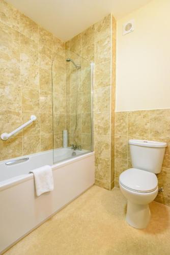 a bathroom with a toilet and a bath tub at Ocean View Hotel in Shanklin