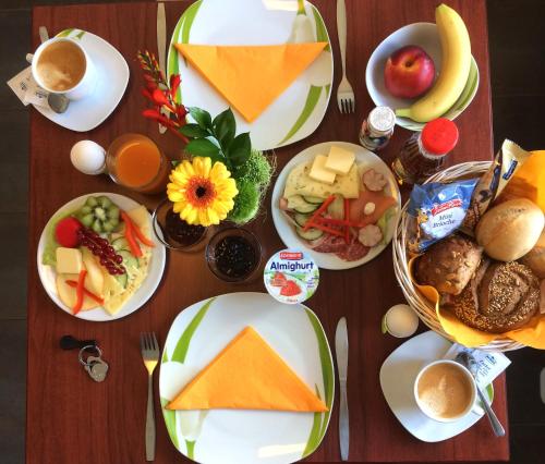 a wooden table with plates of food on it at SchlafGut AppartementHotel in Leipzig