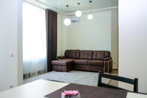 uma sala de estar com um sofá e uma mesa em Family House em Vinnytsya