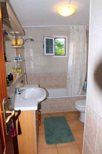 a bathroom with a sink and a tub and a toilet at Casa Nea in El Rosario