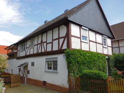 a white and brown house with ivy at Small apartment in Hesse with terrace and garden in Frielendorf