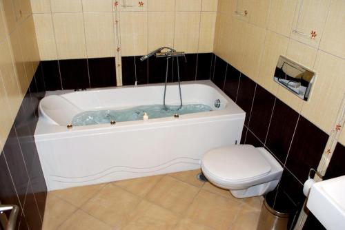 Vina Beach Hotel في سكيروس: حمام مع حوض استحمام ومرحاض