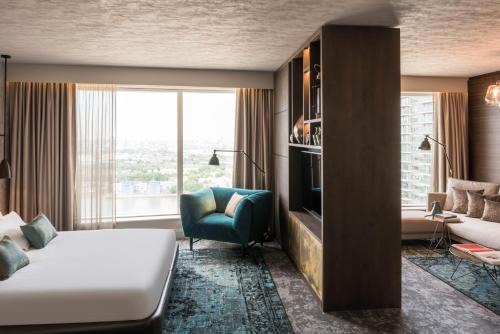 a hotel room with a bed and a couch and a window at Novotel London Canary Wharf in London