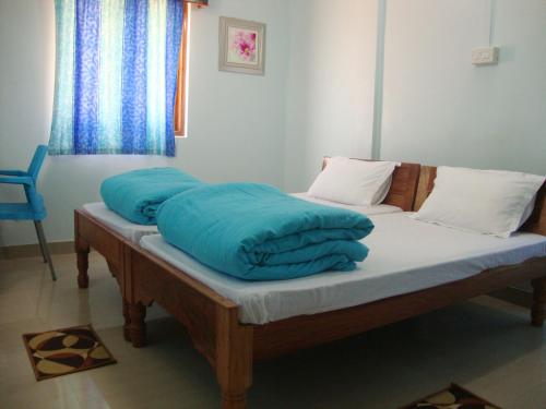a bed with blue pillows on top of it at The Port Vista in Port Blair