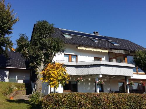 una casa blanca con techo negro en Apartment in Kniebis with garden seating area, en Kniebis