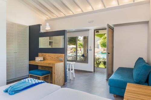 a bedroom with a bed and a desk with a blue couch at Stellina Village in Kato Daratso