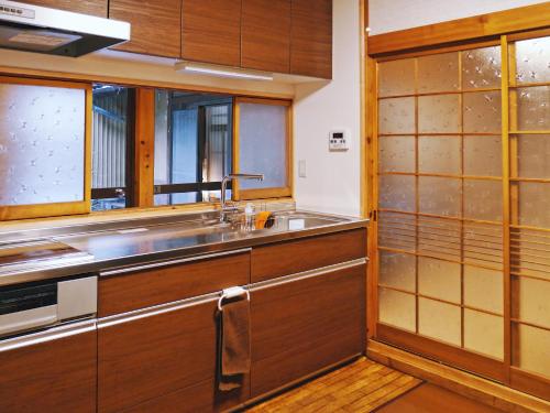 a kitchen with wooden cabinets and a sink at K's Villa Hida-an in Takayama