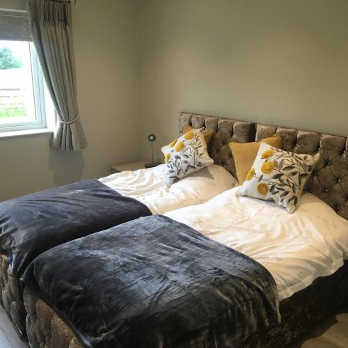 a bedroom with a large bed with pillows on it at Palms Cottage in Blackburn