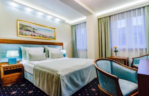 ジェシュフにあるGrein Hotelのベッドと椅子付きのホテルルーム