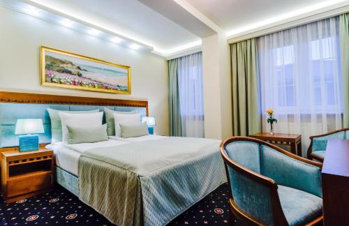 pokój hotelowy z łóżkiem i krzesłem w obiekcie Grein Hotel w mieście Rzeszów