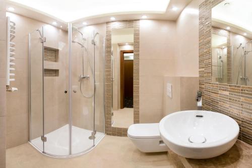a bathroom with a shower and a toilet and a sink at Grein Hotel in Rzeszów
