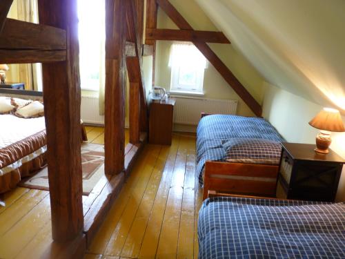 a attic room with two beds and wooden floors at Sloneczna Weranda in Wydminy