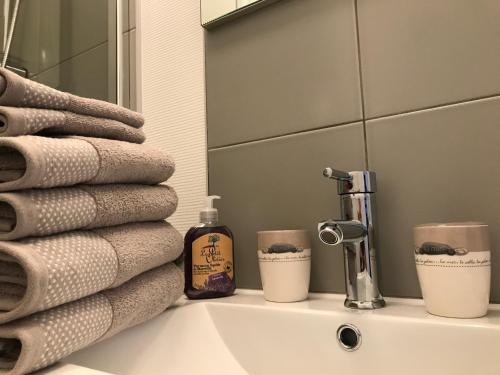 a bathroom sink with towels and a mirror at Vue mer à Arromanches in Arromanches-les-Bains