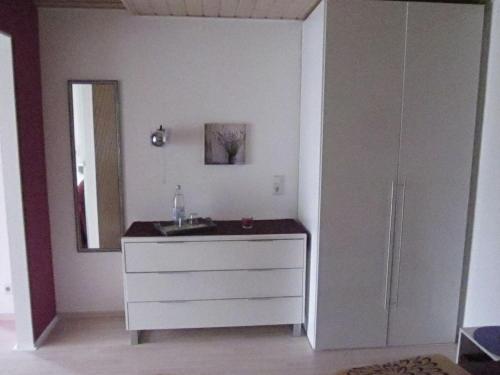 y baño con tocador blanco y espejo. en Ferienwohnung Bambusgarten en Mössingen