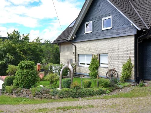 a house with a statue in front of a yard at Apartment in Kirchhundem in the middle of nature in Silberg