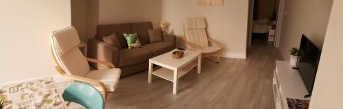 a living room with a couch and chairs and a table at Apartmentos El Alfar del Sacramento in Toledo