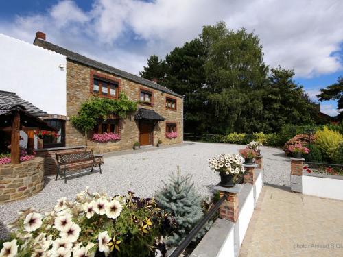 un patio de una casa con un banco y flores en Spacious holkiday home in Mettet with large garden, en Mettet