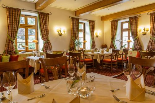 a restaurant with tables and chairs and windows at Landhotel Donner in Meschede