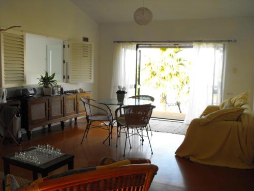 a living room with a table and chairs and a window at Rangimarie Anaura Bay Beachstay in Anaura Bay