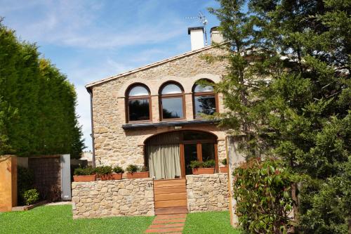 a stone house with a window and a stone wall at El Racó de Madremanya - Adults only in Madremanya