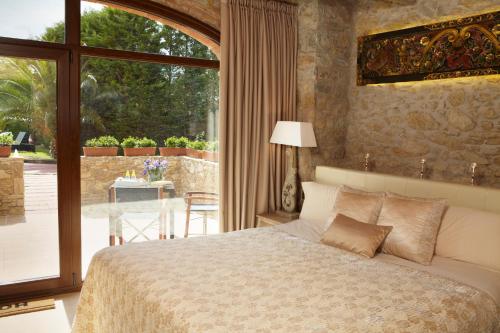 a bedroom with a bed and a large window at El Racó de Madremanya - Adults only in Madremanya