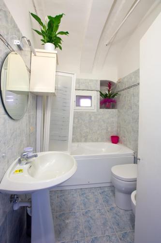 a bathroom with a sink and a tub and a toilet at Casa del Borgo in Finale Ligure