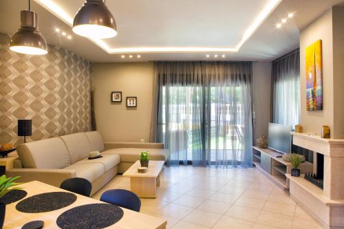 a living room with a couch and a tv at Mezonetes Toroni in Toroni