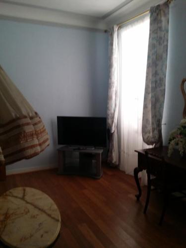 - un salon avec une télévision à écran plat à côté d'une fenêtre dans l'établissement Meublé Tourisme, à Marseille