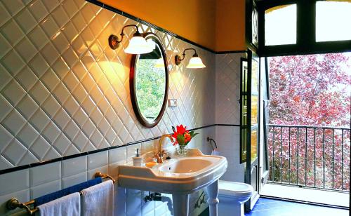 een badkamer met een wastafel, een toilet en een raam bij Hostal Palacio Jaureguia in Irurita