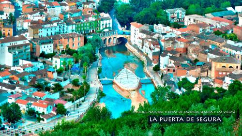 an aerial view of a city with a bridge and a river at La Vieja Parra in La Puerta de Segura