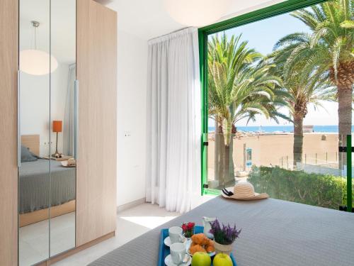 a bedroom with a view of the beach from a room with a table at Apartment Las Burras in San Agustin