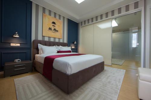 1 dormitorio con 1 cama extragrande y 1 silla en Mr Nice Apartments, Highvill-Astana, en Astana