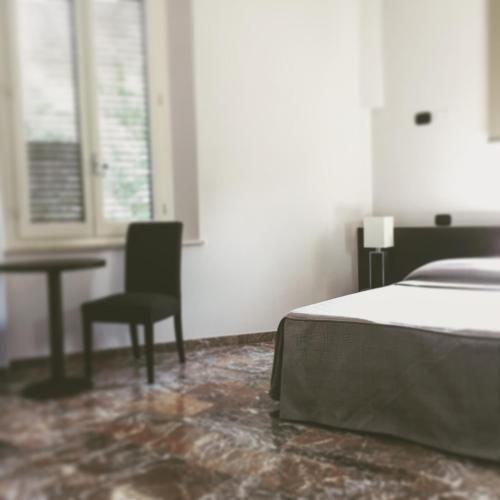 a bedroom with a bed and a chair and a table at Boutique Hotel Liberty 1904 in Bologna