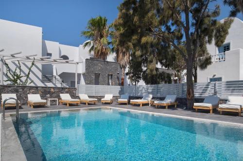 a swimming pool with lounge chairs and a resort at Meltemi Excelsior Suites in Perissa