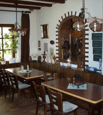 ブラウンフェルスにあるガストハウス ゴムベルのテーブルと椅子のあるレストランで、壁にメニューを用意しています。