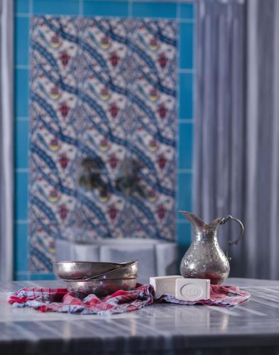 a table with a vase and a plate on it at Palmin Hotel in Kusadası